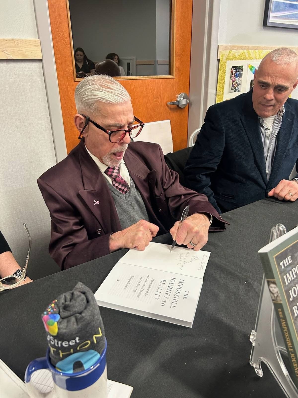 Joseph Ferreira signing a copy of his book at an event